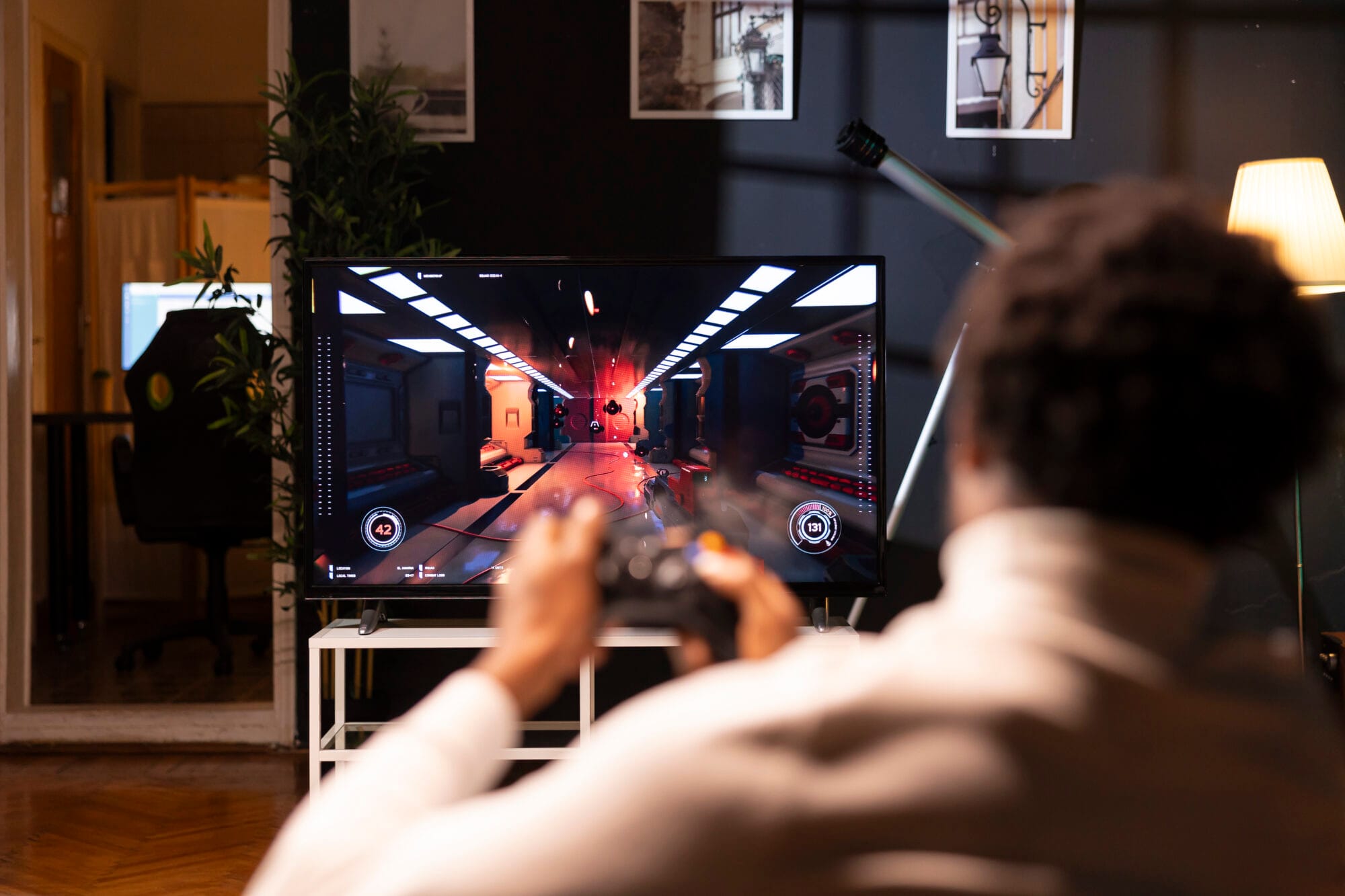 Player using controller to play first person shooter videogame on smart TV